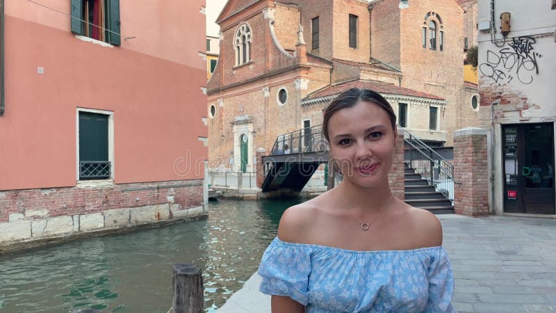 один человек - женщина в возрасте 30 лет в синем топе. она выглядит радостно улыбающейся и смеющейся, смотря на акции видеоматериалы