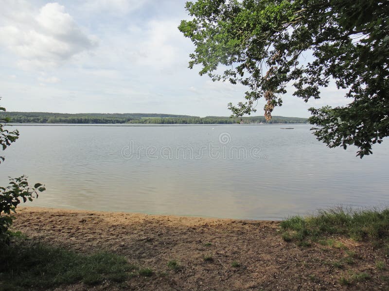 Озеро Brombachsee с изумлять дикий располагаться лагерем леса и лета клонит изящное искусство предпосылки праздников в высококаче стоковое изображение rf