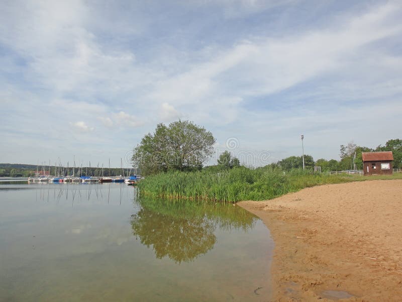 Озеро Brombachsee с изумлять дикий располагаться лагерем леса и лета клонит изящное искусство предпосылки праздников в высококаче стоковые изображения rf