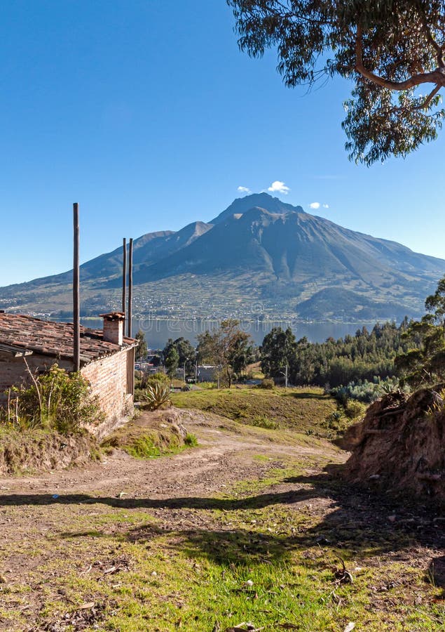 View of the Imbabura volcano, San Pablo lake, surrounding fields and a small cabin, on a clear morning. Ecuador. View of the Imbabura volcano, San Pablo lake, surrounding fields and a small cabin, on a clear morning. Ecuador