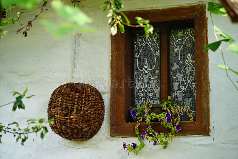 Old stylish opened windows with beautiful purple blooming flowers and a wicker basket. Old stylish opened windows with beautiful purple blooming flowers and a wicker basket.