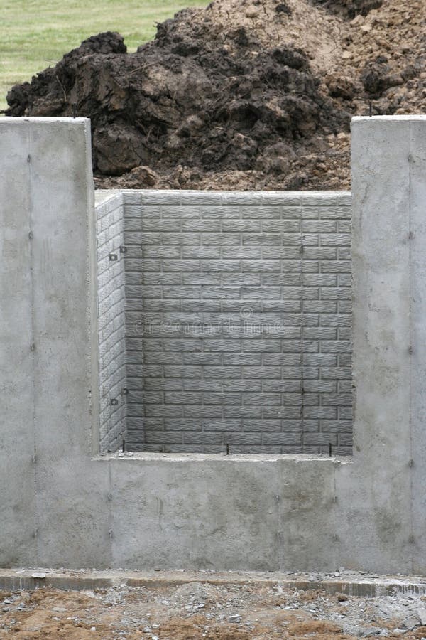 Basement wall with daylight window showing brick textured interior also included in view are wall tie ends protruding. New codes require basements to have daylight windows to be used as fire escapes. Basement wall with daylight window showing brick textured interior also included in view are wall tie ends protruding. New codes require basements to have daylight windows to be used as fire escapes