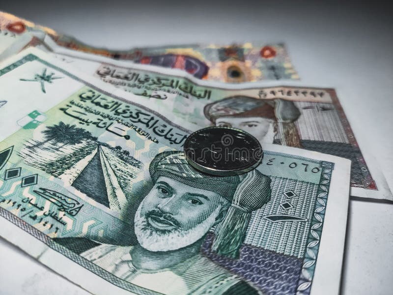 Оманские 50 baiza монеты 100 риалов baiza baiza 500 и 5 риалов заметок валюты лежат на столе.
