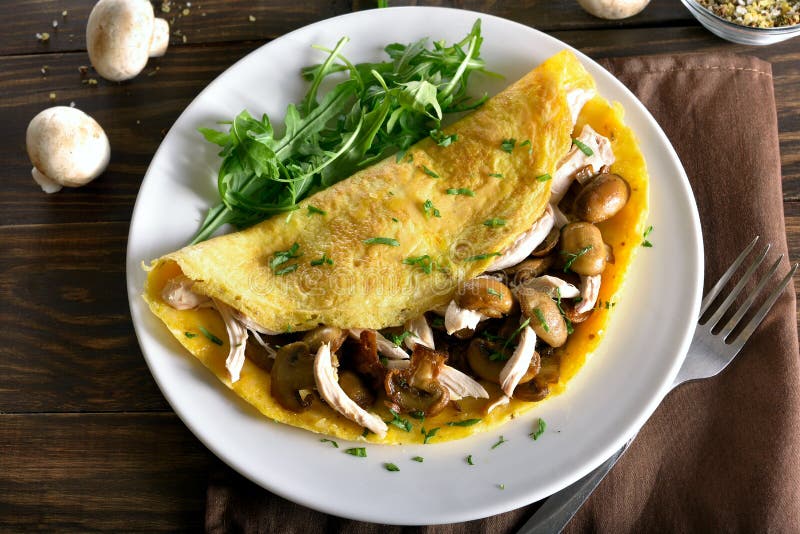 Омлет заполненный с грибами, частями мяса цыпленка, зелеными цветами стоковое изображение rf Омлет заполненный с грибами, частями мяса цыпленка, зелеными цветами стоковое изображение rf