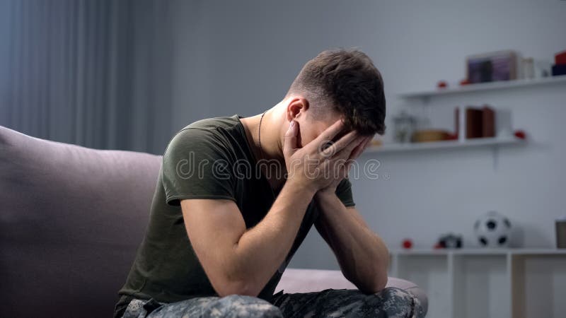 Depressed soldier crying at home, remembering dead fellows and horrors of war, stock photo. Depressed soldier crying at home, remembering dead fellows and horrors of war, stock photo