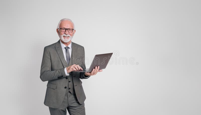 Experienced smiling male professional checking e-mails over laptop on isolated white background. Experienced smiling male professional checking e-mails over laptop on isolated white background.