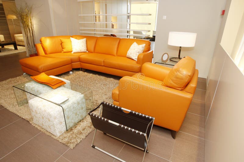 Оранжевые кожаные кресло и кресло установили в мебель