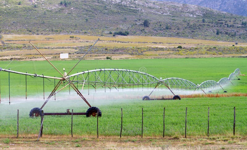 Farm field irrigation system watering plants. Farm field irrigation system watering plants