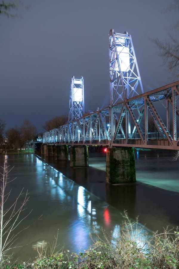 Освещенный пешеходный мост пересекая Willamette Tr преобразованный рекой стоковое фото rf Освещенный пешеходный мост пересекая Willamette Tr преобразованный рекой стоковое фото rf