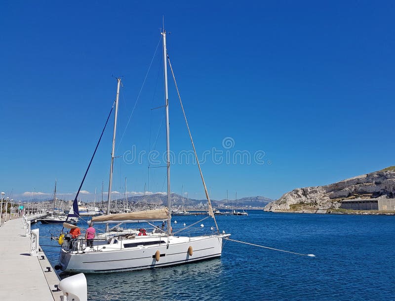 Остров/Франция Ratonneau - могут 8, 2017: Экипаж sailingboat подготавливает нашу яхту к плавать Меньшее зачаливание яхты около пр стоковая фотография rf Остров/Франция Ratonneau - могут 8, 2017: Экипаж sailingboat подготавливает нашу яхту к плавать Меньшее зачаливание яхты около пр стоковая фотография rf