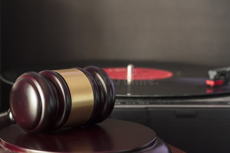 Judge`s gavel and vinyl record player. Concept of entertainment lawsuit, music piracy and copyright protection. Judge`s gavel and vinyl record player. Concept of entertainment lawsuit, music piracy and copyright protection.