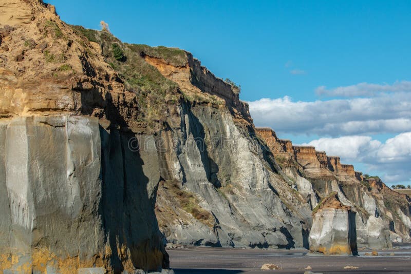 Отвесные скалы смотря на на пляж на пляже Kai Iwi в Whanganui стоковые изображения Отвесные скалы смотря на на пляж на пляже Kai Iwi в Whanganui стоковые изображения