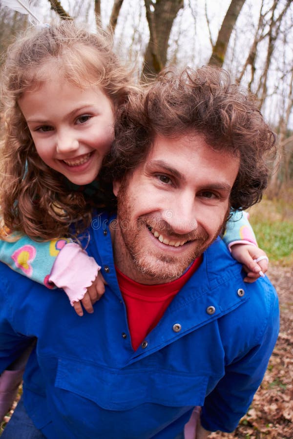 Father Giving Daughter Piggyback Ride On Countryside Walk. Father Giving Daughter Piggyback Ride On Countryside Walk