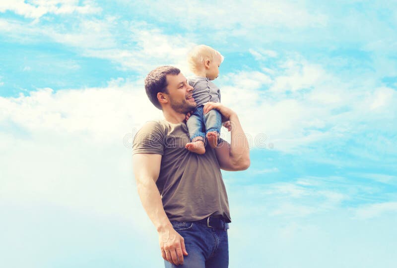 Lifestyle atmospheric photo happy father and son outdoors against blue sky with clouds - happy family, father's day and childhood concept. Lifestyle atmospheric photo happy father and son outdoors against blue sky with clouds - happy family, father's day and childhood concept