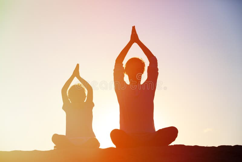 Father and son doing yoga at sunset sky, active family. Father and son doing yoga at sunset sky, active family