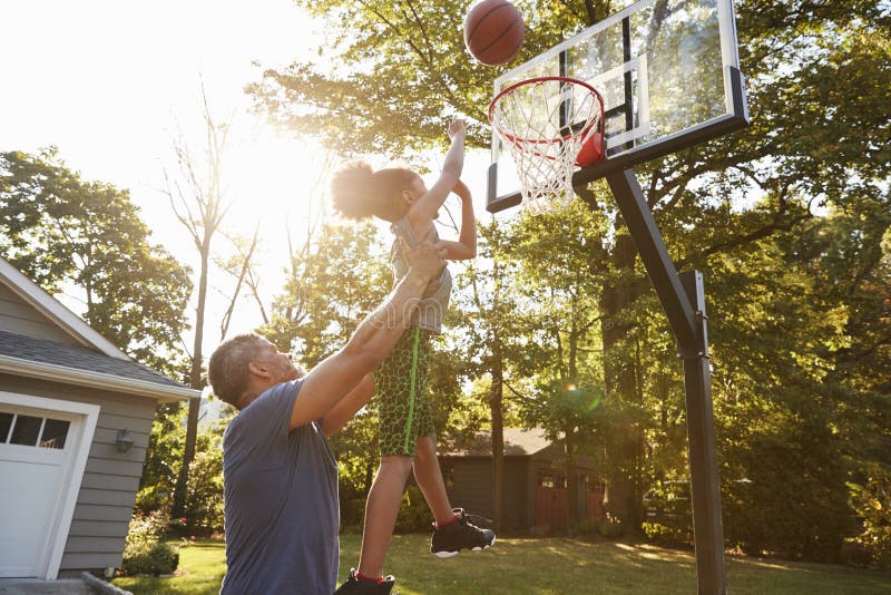 Father And Son Playing Basketball On Driveway At Home. Father And Son Playing Basketball On Driveway At Home