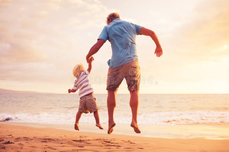 Father and son jumping for joy on the beach at sunset. Father and son jumping for joy on the beach at sunset