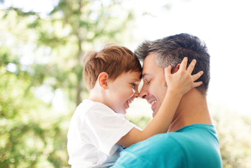 Father and son hugging outdoors, shallow depth of field. Father and son hugging outdoors, shallow depth of field