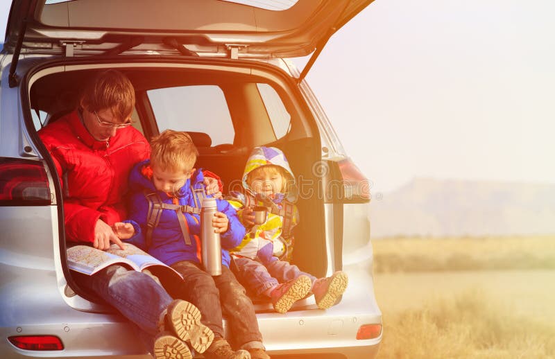 Отец с детьми путешествует автомобилем в горах