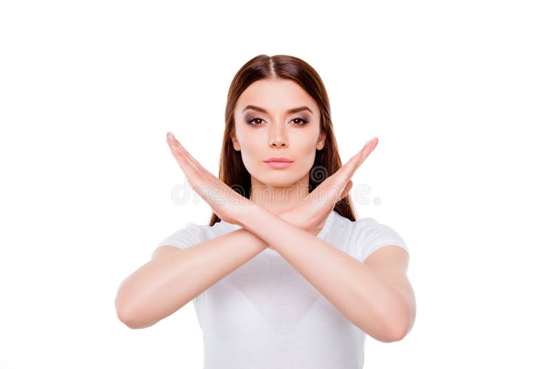 No way! Young brunette woman is making stop gesture, standing in white outfit, on a white background, serious. No way! Young brunette woman is making stop gesture, standing in white outfit, on a white background, serious