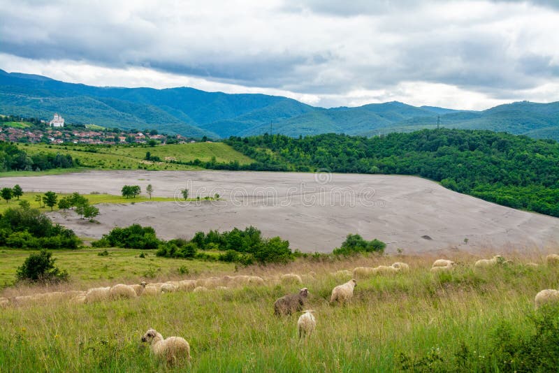 the tailings dumps of a mine between the green hills. the tailings dumps of a mine between the green hills