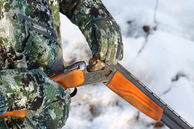 Охотник нагружая его старого русского двух-barreled над и под корокоствольным оружием стоковые изображения Охотник нагружая его старого русского двух-barreled над и под корокоствольным оружием стоковые изображения