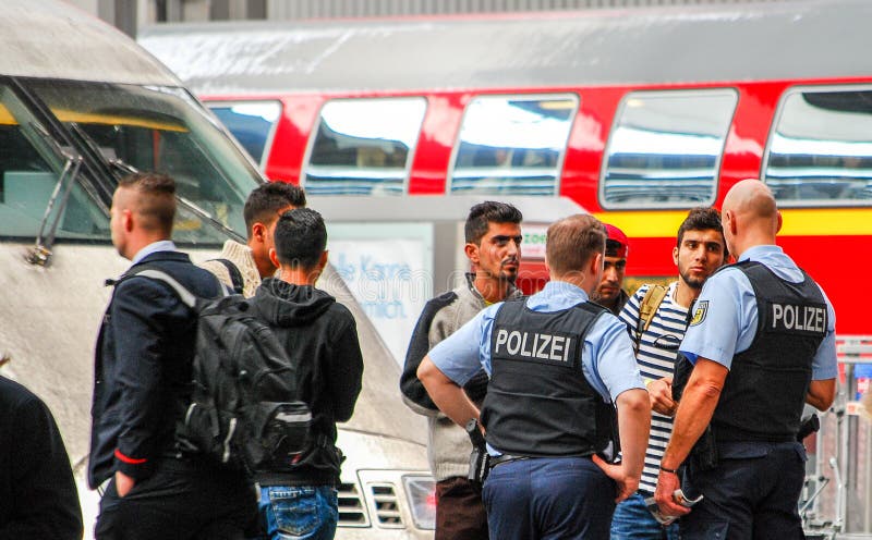 Police talk to several migrants that arrived by train in Munich Central Station in Munich,Germany. Police talk to several migrants that arrived by train in Munich Central Station in Munich,Germany