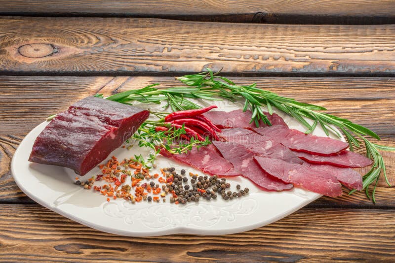 Очень вкусная отрезанная ложь частей отрывистая на деревянной предпосылке, вокруг перца чилей, травы, специи стоковое изображение Очень вкусная отрезанная ложь частей отрывистая на деревянной предпосылке, вокруг перца чилей, травы, специи стоковое изображение