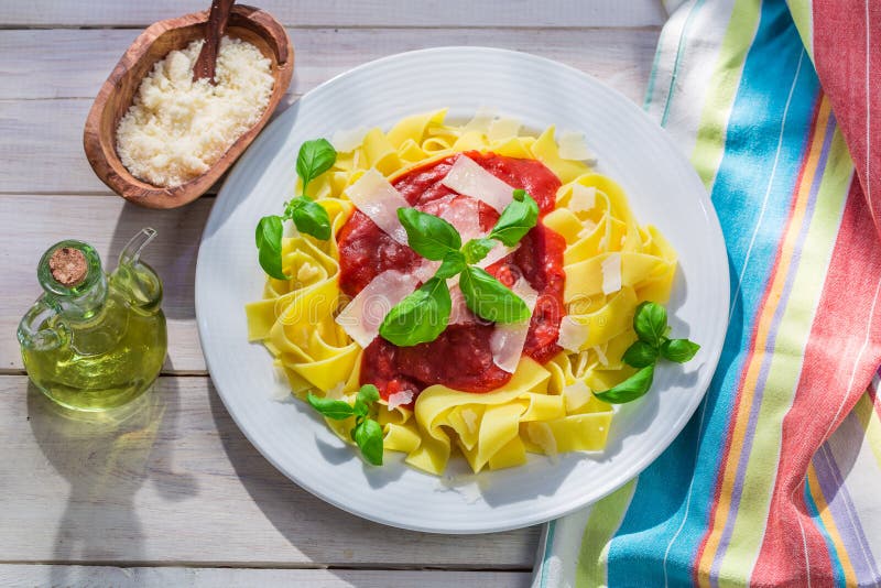 Очень вкусные макаронные изделия pappardelle с томатом, базиликом и пармезаном стоковая фотография Очень вкусные макаронные изделия pappardelle с томатом, базиликом и пармезаном стоковая фотография
