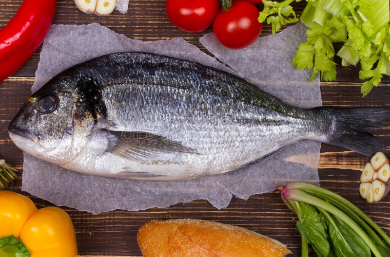 Очень вкусные свежие рыбы и овощи на темной винтажной предпосылке стоковое изображение
