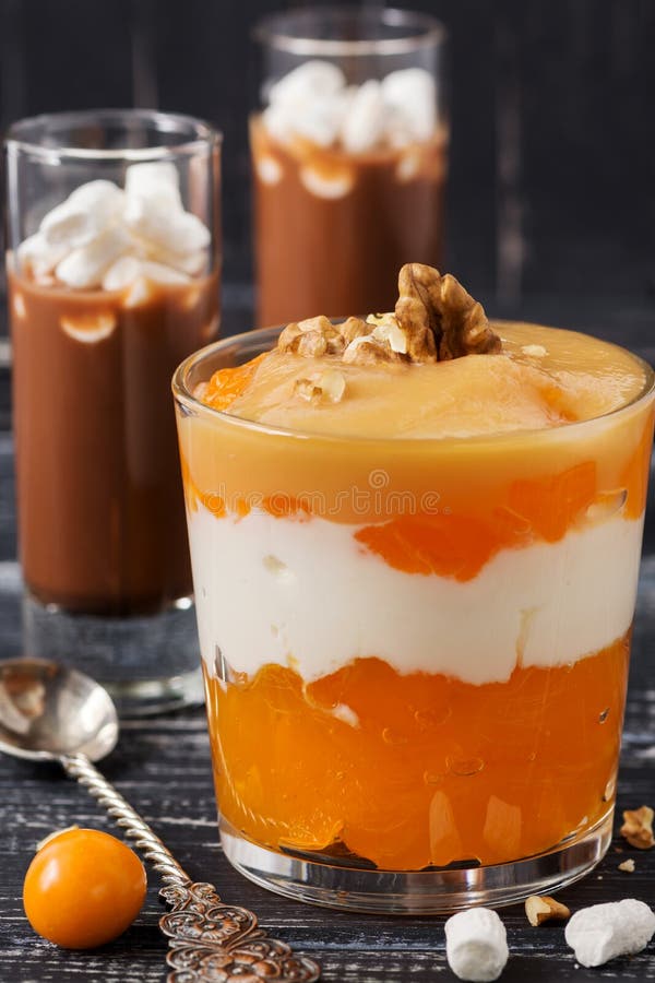 Очень вкусные слои десерта гаек хурмы югурта Десерт послужен в стекле на салфетке с ложкой стоковые изображения Очень вкусные слои десерта гаек хурмы югурта Десерт послужен в стекле на салфетке с ложкой стоковые изображения
