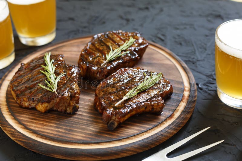 Очень очень вкусный BBQ стейка и пиво в стеклах на черной каменной предпосылке стоковые изображения rf Очень очень вкусный BBQ стейка и пиво в стеклах на черной каменной предпосылке стоковые изображения rf
