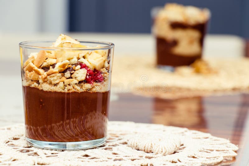 Очень вкусный десерт с пудингом банана и шоколада печениь в стеклянной чашке на таблице стоковая фотография