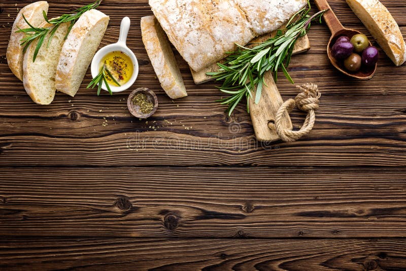 Очень вкусный домодельный итальянский хлеб ciabatta с оливковым маслом и оливками на деревянной деревенской предпосылке, над взгл стоковое изображение rf Очень вкусный домодельный итальянский хлеб ciabatta с оливковым маслом и оливками на деревянной деревенской предпосылке, над взгл стоковое изображение rf