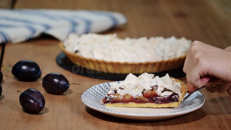 Очень вкусный отрезанный торт зрелого конца-вверх слив на таблице