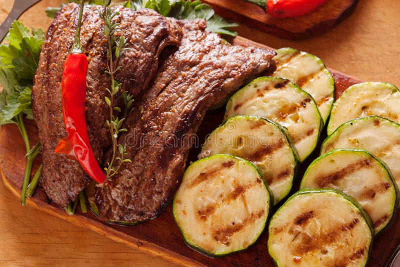 Очень вкусный стейк говядины с овощем над деревянным столом стоковые фотографии rf Очень вкусный стейк говядины с овощем над деревянным столом стоковые фотографии rf