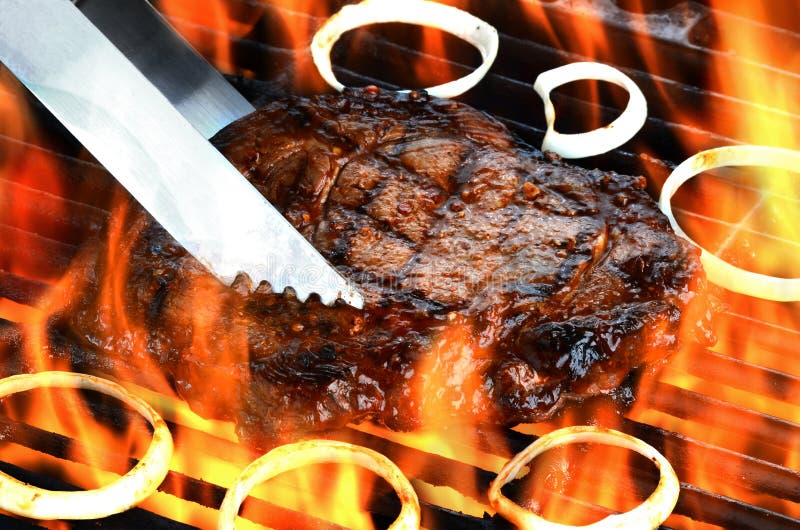 Очень вкусным broiled пламенем стейк глаза нервюры на пламенеющей решетке стоковая фотография rf Очень вкусным broiled пламенем стейк глаза нервюры на пламенеющей решетке стоковая фотография rf
