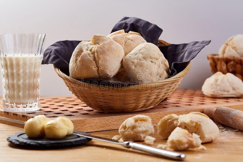 Плюшки хлеба пшеницы в корзине Свежие вкусные плюшки на деревянном столе стоковые изображения Плюшки хлеба пшеницы в корзине Свежие вкусные плюшки на деревянном столе стоковые изображения