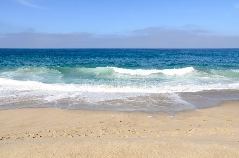 This is a picture of a beautiful beach in California, USA. The waves are crashing against the shore. There are footprints in the sand. This is a picture of a beautiful beach in California, USA. The waves are crashing against the shore. There are footprints in the sand.