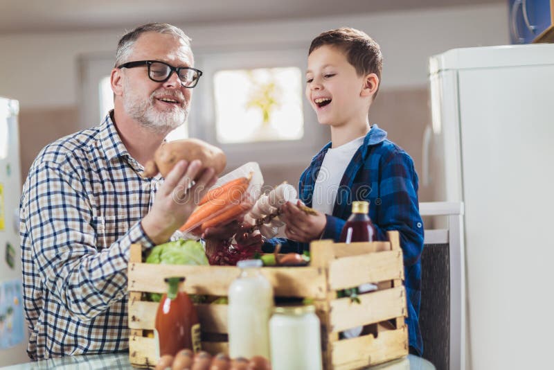 Пакет свежих продуктов к stayathome отцу и сыну. стоковая фотография rf