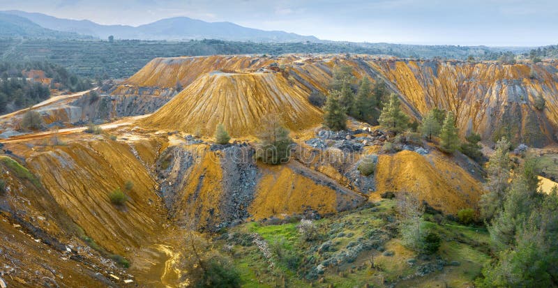 Panorama of vivid yellow tailings from abandoned Memi pyrite mine on Cyprus,with area being restored and reforestation going on. Panorama of vivid yellow tailings from abandoned Memi pyrite mine on Cyprus,with area being restored and reforestation going on
