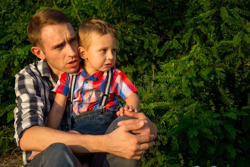Папа утихомиривает его маленького сына который вспугнут и идет заплакать стоковая фотография rf