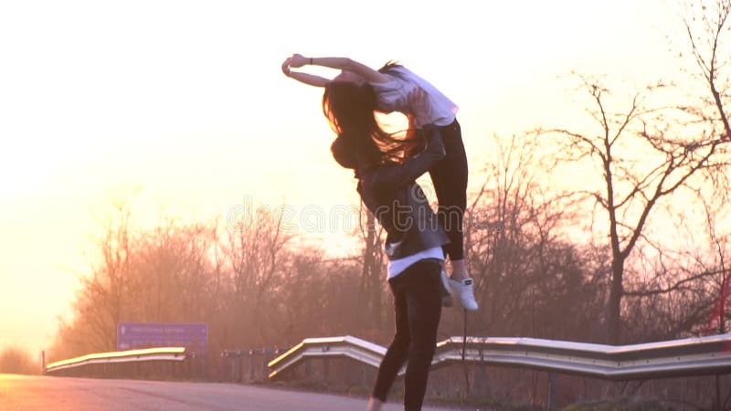 Пара артистов балета на дороге танцует, человек выполняет поддержку в воздухе