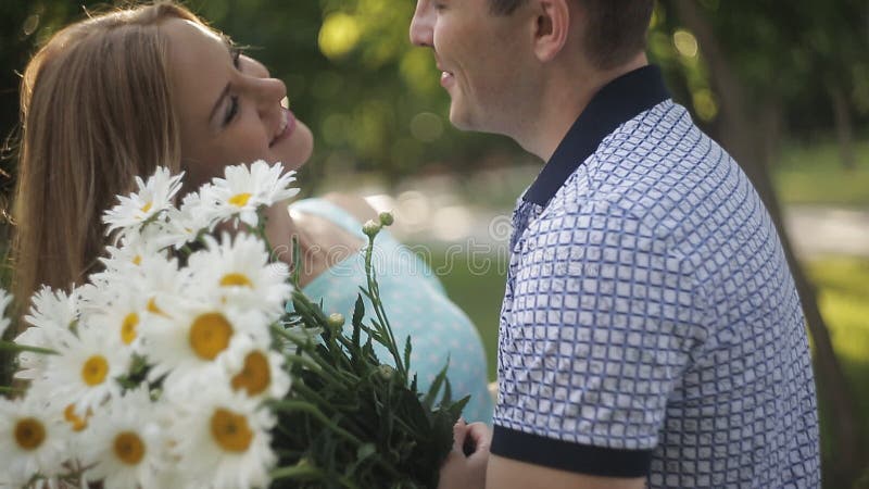 Пара в влюбленности на дате Парень дает девушке букет стоцветов