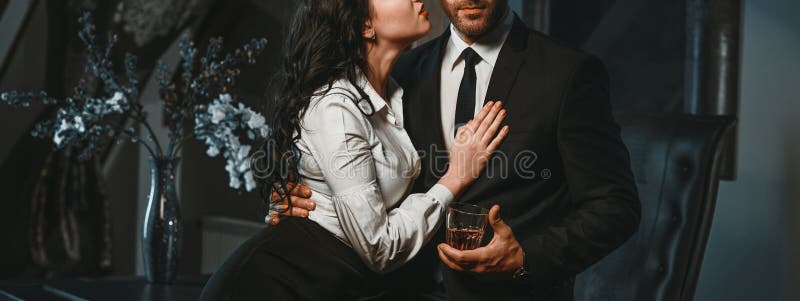 Cropped photo horizontal view couple in love hugging indoors. Sensual brunette and handsome businessman. Office romance concept. Cropped photo horizontal view couple in love hugging indoors. Sensual brunette and handsome businessman. Office romance concept