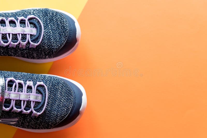 Пара дисплея shoesshop спорта с голубой обуви кроссовок изолированных на светлом фоне оранжевой. Новое модное стоковые фотографии rf