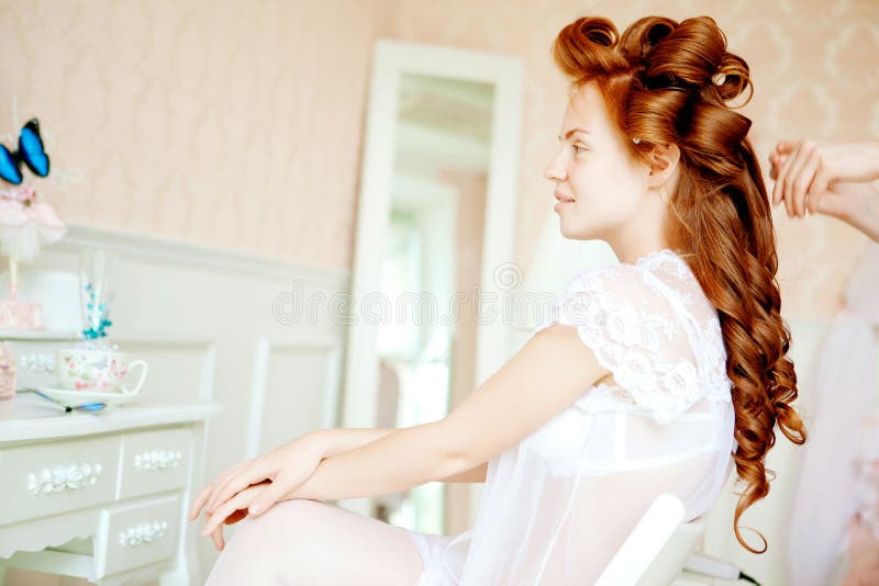 Hair stylist makes the bride before the wedding. Hair stylist makes the bride before the wedding