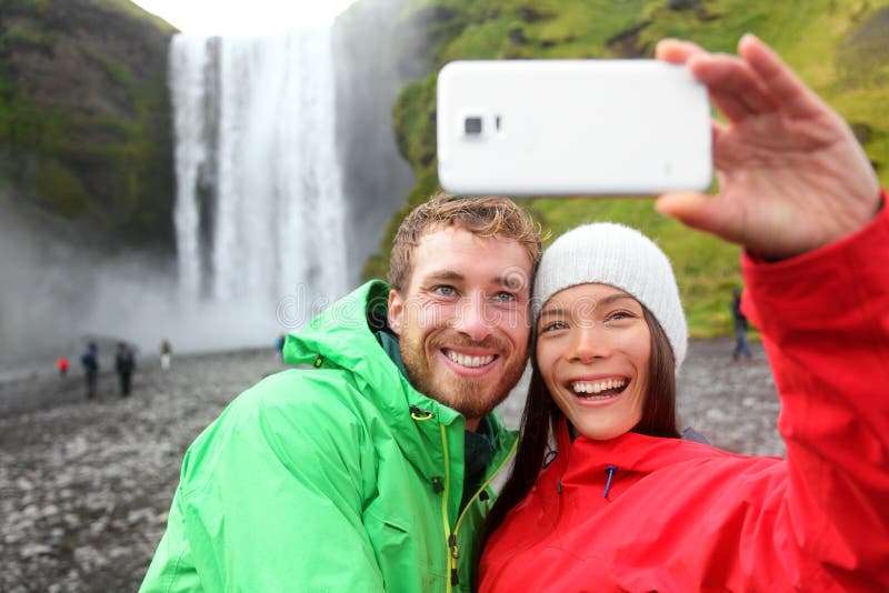 Пары Selfie принимая водопад изображения smartphone стоковая фотография Пары Selfie принимая водопад изображения smartphone стоковая фотография