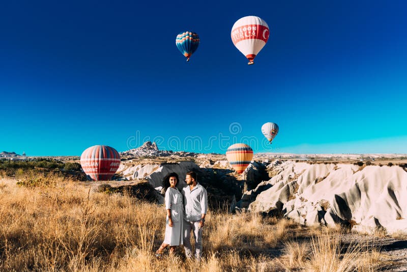 Пары в любов среди воздушных шаров Счастливые пары в Cappadocia Медовый месяц в горах Путешествовать человека и женщины Летание н стоковое изображение rf Пары в любов среди воздушных шаров Счастливые пары в Cappadocia Медовый месяц в горах Путешествовать человека и женщины Летание н стоковое изображение rf