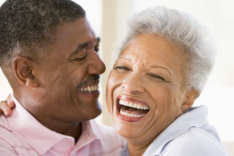 Couple relaxing indoors laughing and smiling. Couple relaxing indoors laughing and smiling